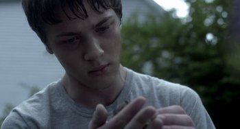 Movie still from “Closet Monster” (2015), directed by Stephen Dunn – A young man holding an insect in his hand; Close Up shot, Over the shoulder angle