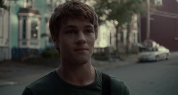 Movie still from “Closet Monster” (2015), directed by Stephen Dunn – A young man is standing in the middle of the street; Close Up shot, Over the shoulder angle