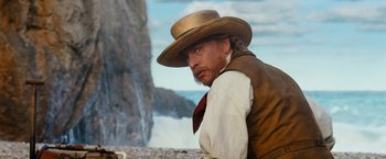 Movie still from “Cloud Atlas” (2012), directed by Lilly Wachowski – A man with a cowboy hat on looking into the distance; Medium shot, Low angle