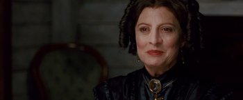 Movie still from “Cloud Atlas” (2012), directed by Lilly Wachowski – An older woman wearing a black dress and a necklace; Close Up shot, Low angle