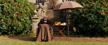 Movie still from “Cloud Atlas” (2012), directed by Lilly Wachowski – An old man sitting in a chair under an umbrella; Wide shot, High angle