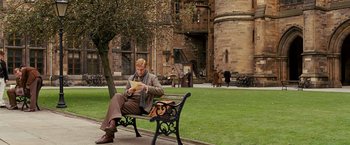 Movie still from “Cloud Atlas” (2012), directed by Lilly Wachowski – A man sitting on top of a park bench reading; Wide shot, High angle