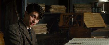 Movie still from “Cloud Atlas” (2012), directed by Lilly Wachowski – A man sitting in front of a laptop computer; Medium shot, Over the shoulder angle