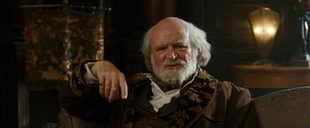 Movie still from “Cloud Atlas” (2012), directed by Lilly Wachowski – An old man with a white beard pointing to the side; Close Up shot, Over the shoulder angle