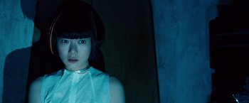 Movie still from “Cloud Atlas” (2012), directed by Lilly Wachowski – A woman with a black wig and a white shirt; Close Up shot, Low angle