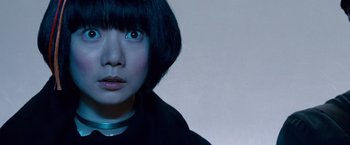 Movie still from “Cloud Atlas” (2012), directed by Lilly Wachowski – A person with short black hair; Close Up shot, Low angle