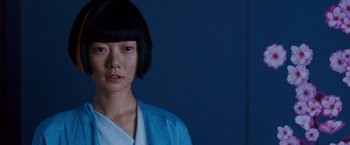 Movie still from “Cloud Atlas” (2012), directed by Lilly Wachowski – A young asian woman in a blue robe; Close Up shot, Low angle