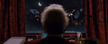 Movie still from “Cloud Atlas” (2012), directed by Lilly Wachowski – A man with a white hair sitting in front of a television; Medium shot, Over the shoulder angle
