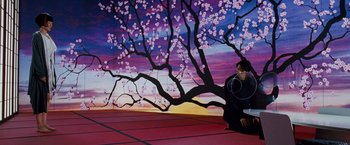 Movie still from “Cloud Atlas” (2012), directed by Lilly Wachowski – A person sitting on the ground under a tree; Wide shot, Low angle