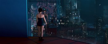 Movie still from “Cloud Atlas” (2012), directed by Lilly Wachowski – A woman standing in front of a large window with a view of a city at night; Wide shot, Over the shoulder angle