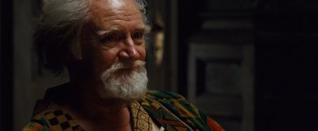 Movie still from “Cloud Atlas” (2012), directed by Lilly Wachowski – An older man with a beard and a colorful scarf; Close Up shot, Over the shoulder angle