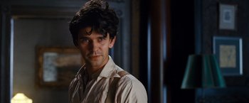 Movie still from “Cloud Atlas” (2012), directed by Lilly Wachowski – A man with a beard is standing in a room; Close Up shot, Over the shoulder angle