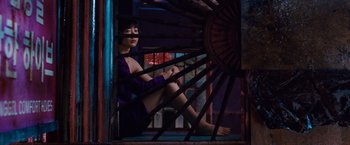 Movie still from “Cloud Atlas” (2012), directed by Lilly Wachowski – A woman in a purple dress sitting in a cage; Wide shot, High angle