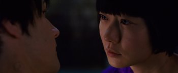 Movie still from “Cloud Atlas” (2012), directed by Lilly Wachowski – Two young people looking at each other in the dark; Extreme Close Up shot, Over the shoulder angle