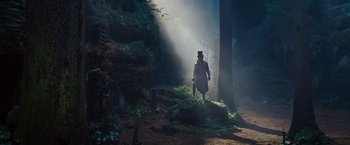 Movie still from “Cloud Atlas” (2012), directed by Lilly Wachowski – A man in a top hat walking through a forest; Wide shot, Low angle