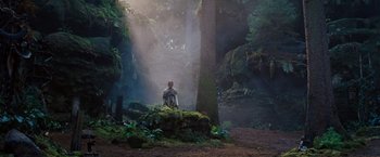 Movie still from “Cloud Atlas” (2012), directed by Lilly Wachowski – A man sitting on a rock in the middle of a forest; Extreme Wide shot, Low angle