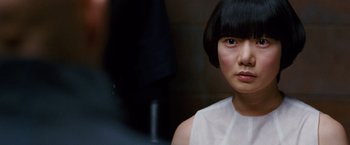 Movie still from “Cloud Atlas” (2012), directed by Lilly Wachowski – A person with short black hair; Close Up shot, Over the shoulder angle