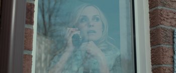 Movie still from “Clown” (2014), directed by Jon Watts – A woman holding a cell phone up to her ear; Close Up shot, High angle