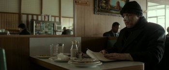 Movie still from “Clown” (2014), directed by Jon Watts – A man sitting at a table in front of a plate of food; Medium shot, Over the shoulder angle