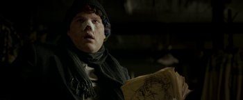 Movie still from “Clown” (2014), directed by Jon Watts – A young man wearing a scarf and hat holding a map; Close Up shot, Low angle