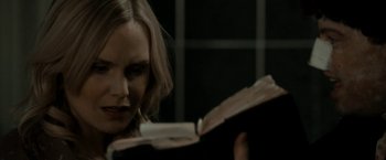 Movie still from “Clown” (2014), directed by Jon Watts – A woman is reading a book in a dark room; Close Up shot, Over the shoulder angle