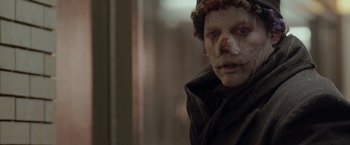 Movie still from “Clown” (2014), directed by Jon Watts – A person with a bandage on his face; Close Up shot, Over the shoulder angle
