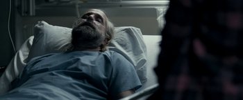 Movie still from “Clown” (2014), directed by Jon Watts – An older man laying in a hospital bed; Close Up shot, Over the shoulder angle