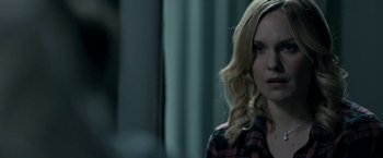 Movie still from “Clown” (2014), directed by Jon Watts – A woman with blonde hair and a plaid shirt looking at the camera; Close Up shot, Over the shoulder angle