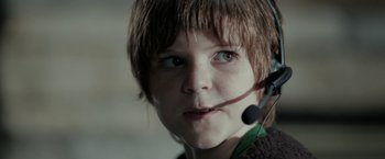 Movie still from “Clown” (2014), directed by Jon Watts – A young boy wearing a headset and looking into the camera; Close Up shot, Low angle