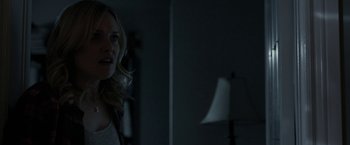 Movie still from “Clown” (2014), directed by Jon Watts – A woman standing next to a lamp in a dark room; Close Up shot, Over the shoulder angle