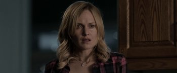 Movie still from “Clown” (2014), directed by Jon Watts – A woman with blonde hair wearing a pink and black plaid shirt; Close Up shot, Over the shoulder angle