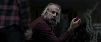 Movie still from “Clown” (2014), directed by Jon Watts – A man with a beard and a red sweater; Close Up shot, Over the shoulder angle