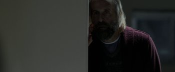 Movie still from “Clown” (2014), directed by Jon Watts – A man with long hair and a goatee looking in a mirror; Close Up shot, Over the shoulder angle