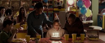 Movie still from “Clown” (2014), directed by Jon Watts – A young boy blows out candles on a birthday cake; Medium shot, High angle