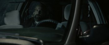 Movie still from “Clown” (2014), directed by Jon Watts – A man sitting in the driver's seat of a car at night; Close Up shot, Over the shoulder angle
