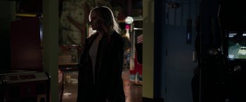 Movie still from “Clown” (2014), directed by Jon Watts – A woman standing in the dark in a room; Medium shot, Over the shoulder angle