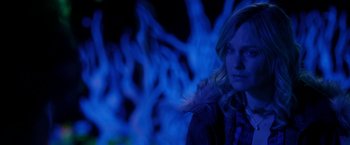 Movie still from “Clown” (2014), directed by Jon Watts – A woman is standing in front of blue lights; Close Up shot, Over the shoulder angle