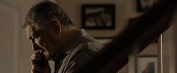 Movie still from “Clown” (2014), directed by Jon Watts – A person sitting in a room; Close Up shot, Low angle