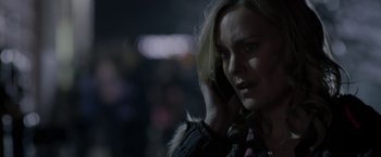 Movie still from “Clown” (2014), directed by Jon Watts – A woman talking on a cell phone while standing in the dark; Close Up shot, Over the shoulder angle