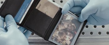 Movie still from “Clown” (2014), directed by Jon Watts – A person holding an open wallet with a picture of a child; Extreme Close Up shot, Overhead angle