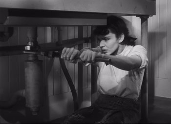 Movie still from “Cluny Brown” (1946), directed by Ernst Lubitsch – A woman is holding onto a rope while sitting on a chair; Medium shot, Low angle