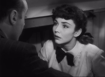 Movie still from “Cluny Brown” (1946), directed by Ernst Lubitsch – A woman in a bow tie talking to a man in a suit and tie; Close Up shot, High angle