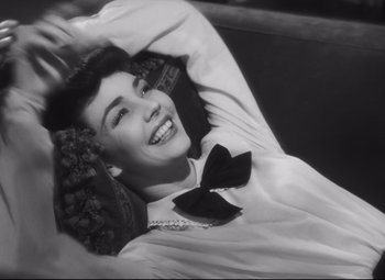 Movie still from “Cluny Brown” (1946), directed by Ernst Lubitsch – An old photo of a young woman smiling for the camera; Close Up shot, High angle