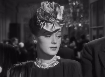 Movie still from “Cluny Brown” (1946), directed by Ernst Lubitsch – A black and white photo of a woman wearing a hat; Close Up shot, Over the shoulder angle