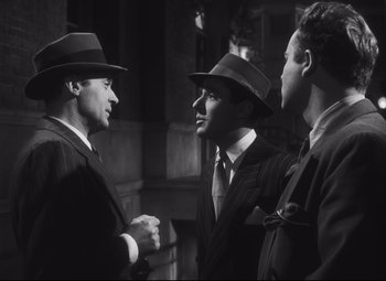 Movie still from “Cluny Brown” (1946), directed by Ernst Lubitsch – A group of men standing next to each other in suits; Medium shot, Over the shoulder angle