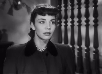 Movie still from “Cluny Brown” (1946), directed by Ernst Lubitsch – A woman in a black coat is looking at the camera; Close Up shot, Over the shoulder angle