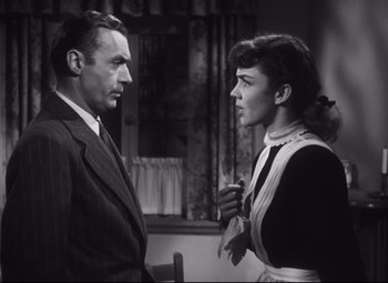 Movie still from “Cluny Brown” (1946), directed by Ernst Lubitsch – A man and a woman standing next to each other in a room; Medium shot, Low angle