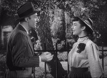 Movie still from “Cluny Brown” (1946), directed by Ernst Lubitsch – A man and a woman standing next to each other near a fence; Medium shot, High angle