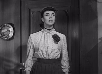 Movie still from “Cluny Brown” (1946), directed by Ernst Lubitsch – A black and white photo of a woman standing in front of a door; Medium shot, Low angle
