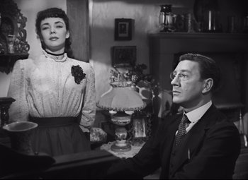 Movie still from “Cluny Brown” (1946), directed by Ernst Lubitsch – A man and a woman sitting in front of a lamp; Medium shot, Low angle